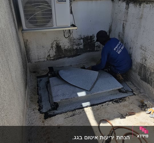 אדם עובד על איטום גג עם יריעות וחומרי איטום